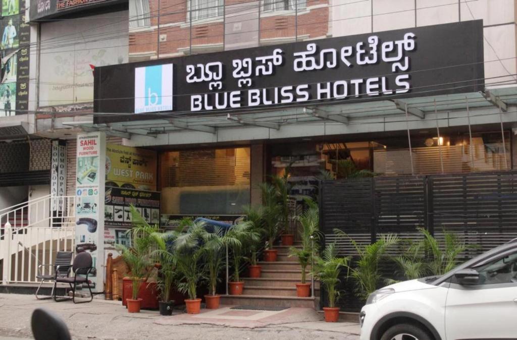 班加罗尔Blue Bliss Hotel By PPH Living的蓝色的公共汽车酒店前面有植物