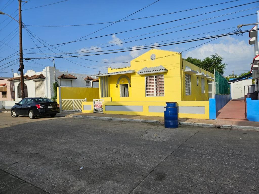阿雷西博Beach Getaway with Cozy 2 Bedrooms near the Ocean, Arecibo的街道边的黄色建筑