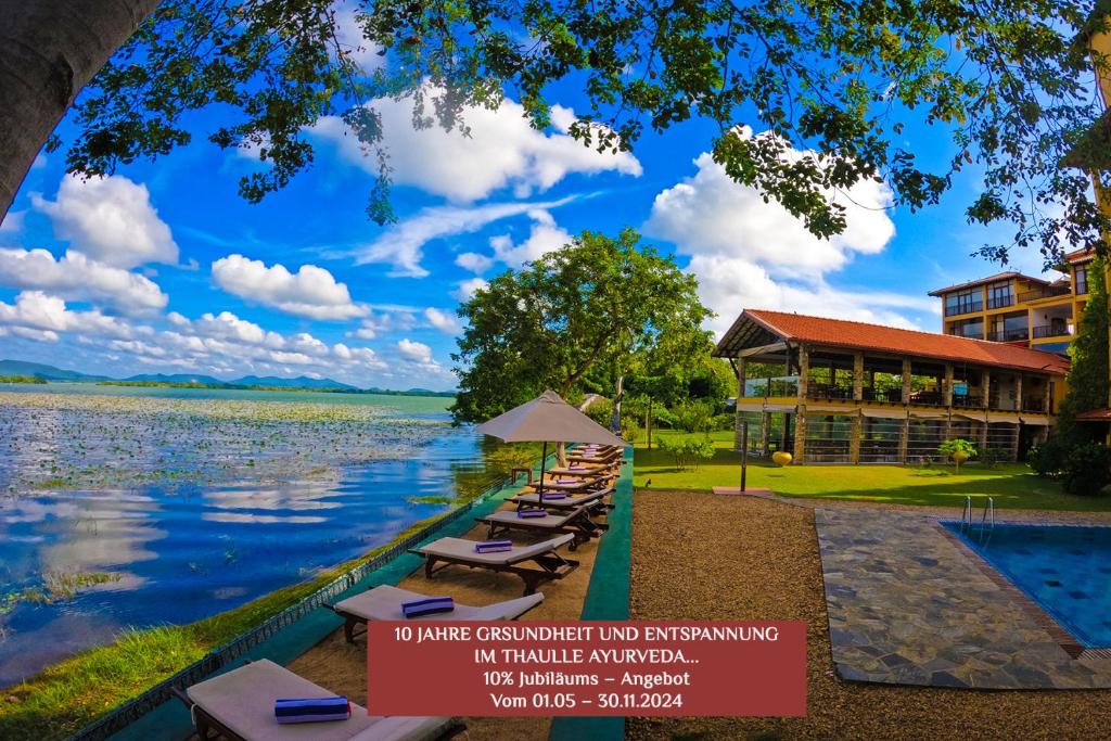 蒂瑟默哈拉默Thaulle Pure Ayurveda Resort - Yala的湖畔一排躺椅