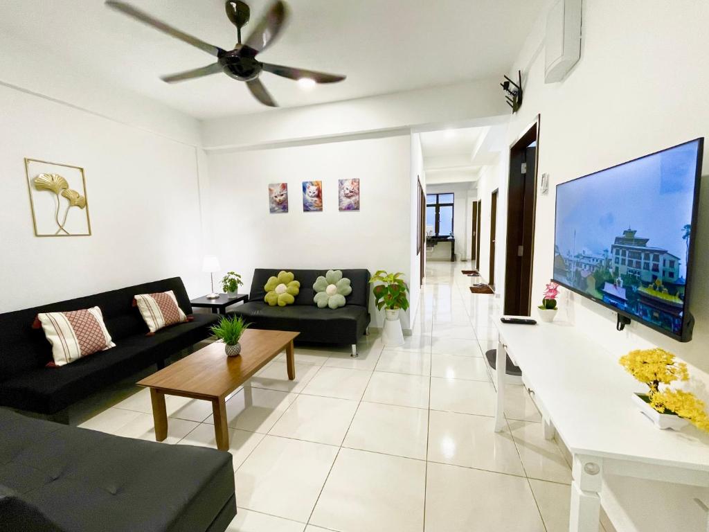瓜拉丁加奴The Urban Lodge 1的客厅配有黑色沙发和平面电视。