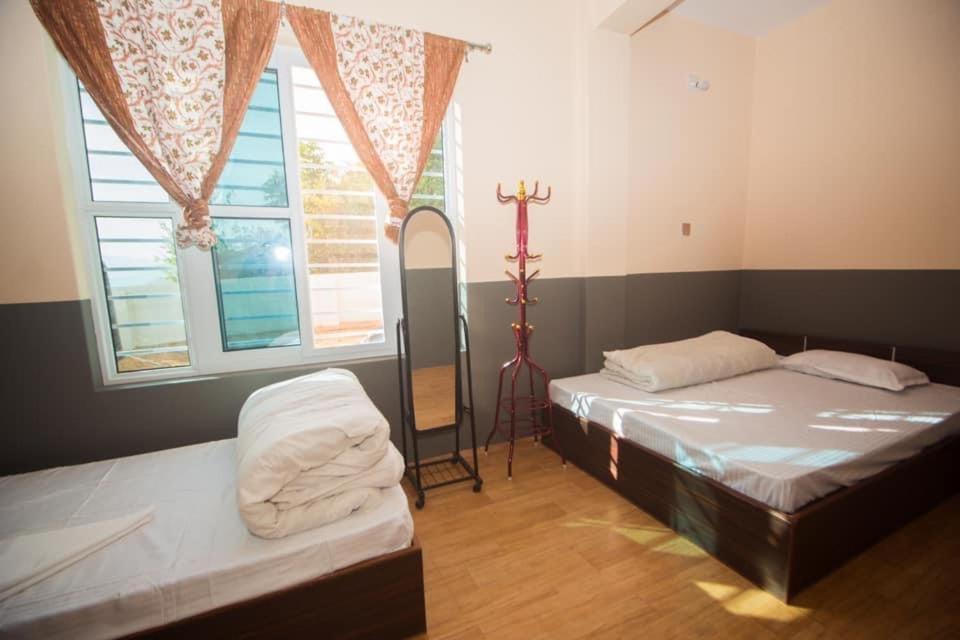 TānsenRanimahal Homestay的一间设有两张床的房间,里面设有十字架