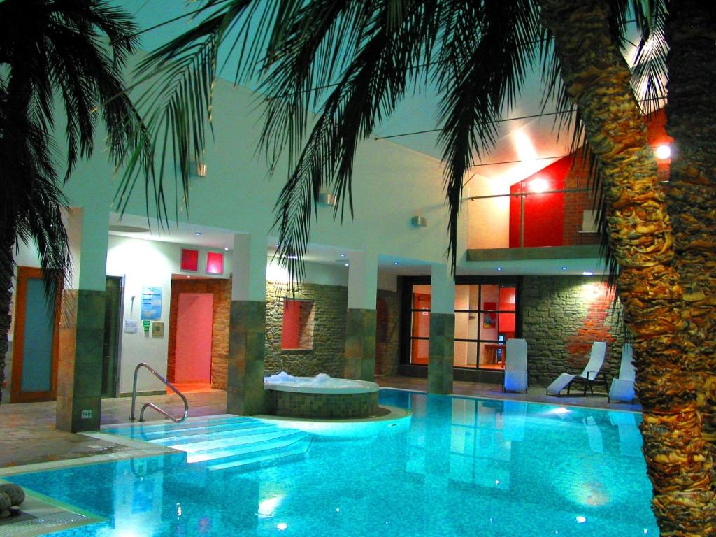 金顿伯顿酒店的一座游泳池,旁边是一座棕榈树