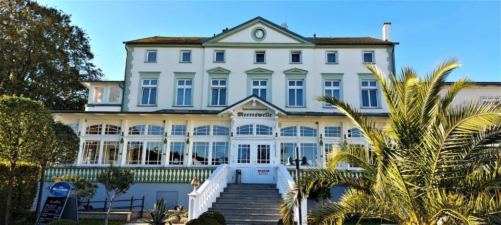 塞巴特阿尔贝克Hotel Meereswelle - Anno 1875的前面有楼梯的大型白色建筑