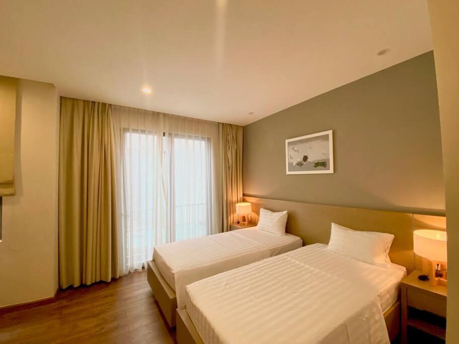 下龙湾5Bedroom Villa close to the sea with a Lake view的酒店客房设有两张床和窗户。
