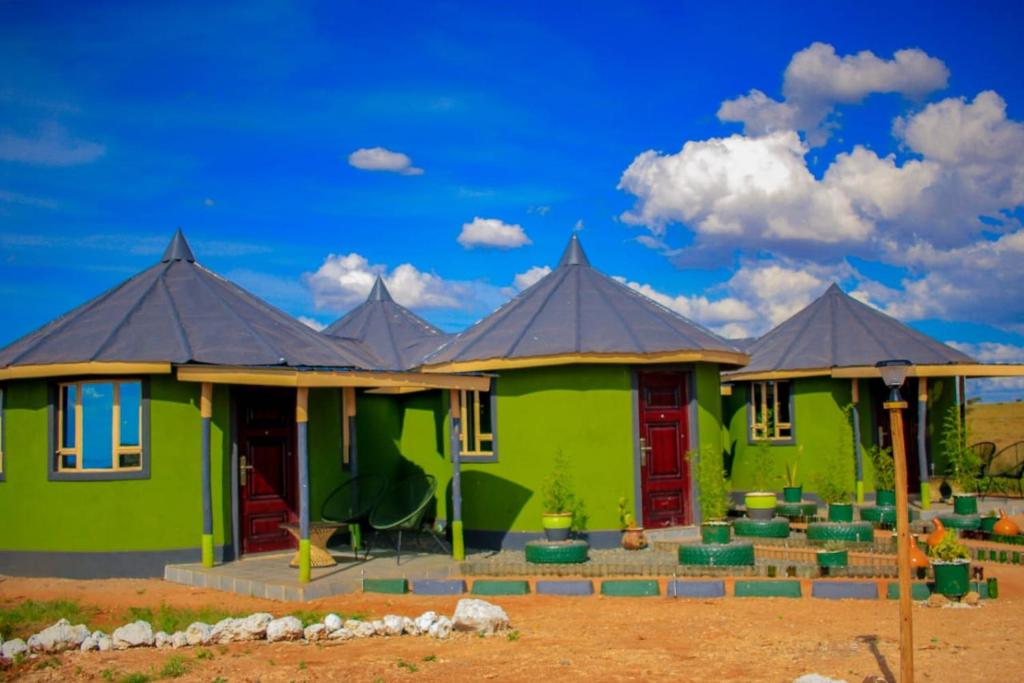 安博塞利Amanya 3-Bedroom Hut Amboseli的黑色屋顶绿色房子