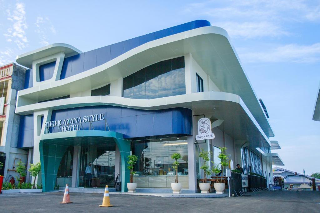 明古鲁省Two K Azana Style Hotel Bengkulu的蓝色和白色的建筑,前面有锥形