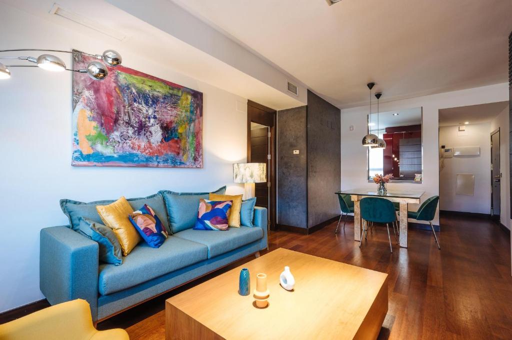 塞维利亚San Bernardo Home Free Parking的客厅配有蓝色的沙发和桌子