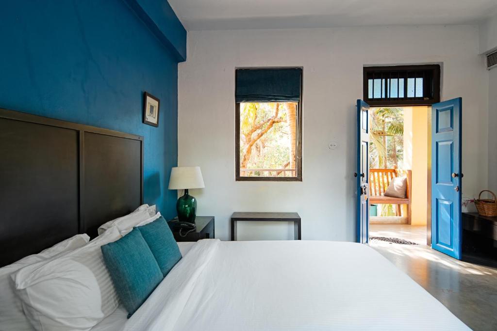 巴加The Secret Cove by Stay ALYF, Baga的一间卧室配有一张白色大床和蓝色的墙壁