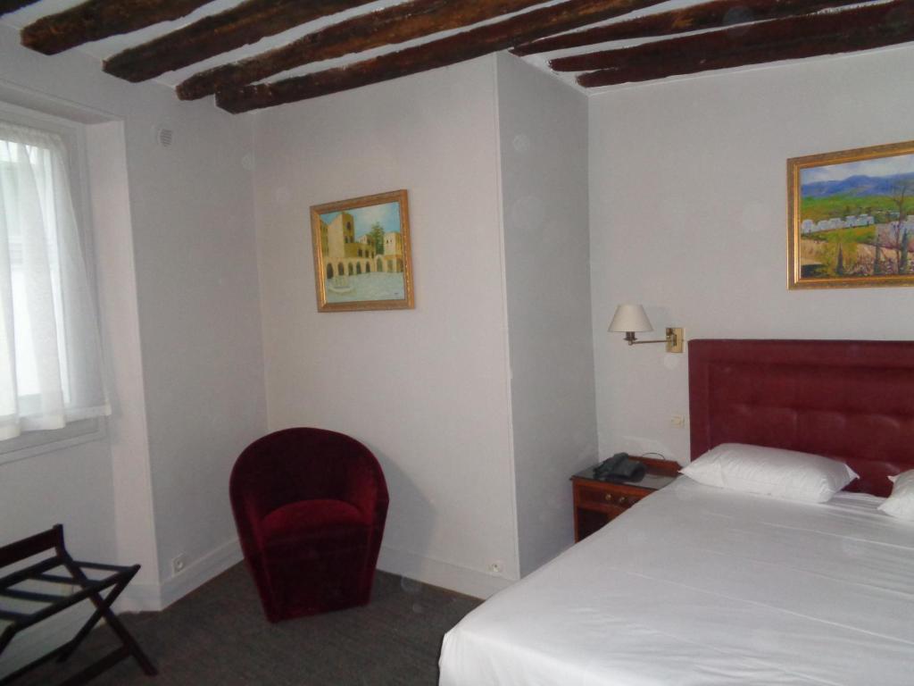 巴黎德格尔巴黎圣母院酒店的一间卧室配有一张床和一张红色椅子