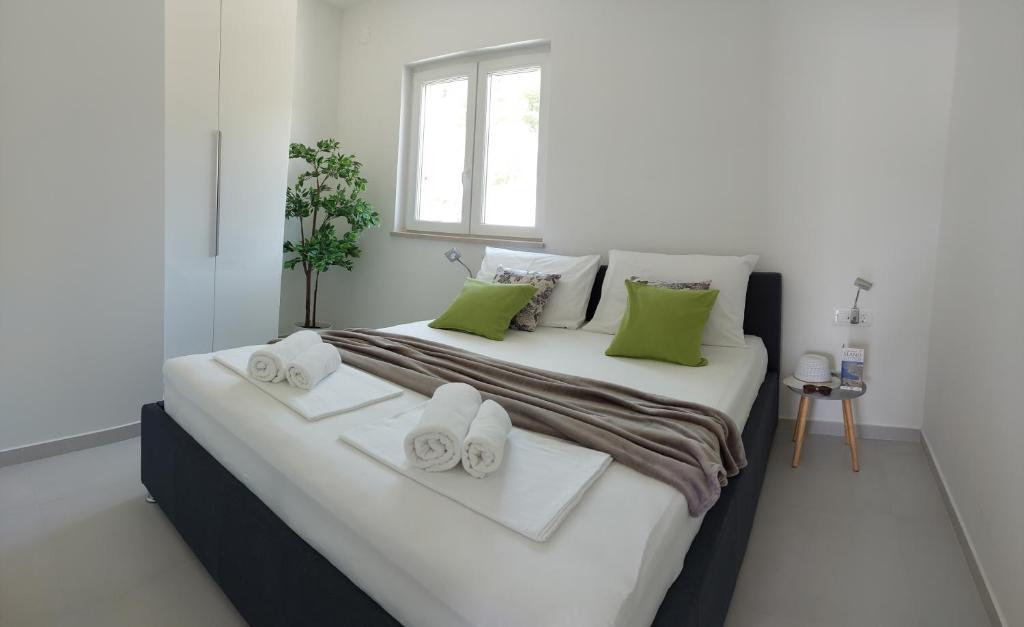 斯拉诺Slano Bay Apartments的一间卧室配有一张大床和毛巾