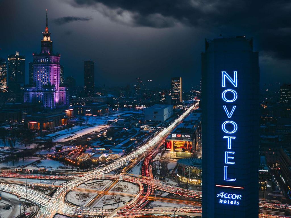华沙华沙中心诺富特酒店的城市的夜间景观,带有标志