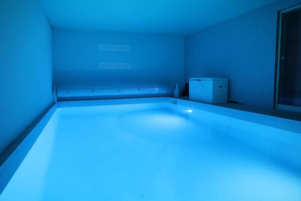奥尔泽姆Villa avec piscine intérieure的一间设有蓝色灯光的床的房间