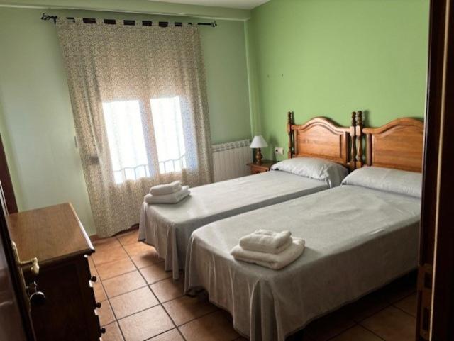 Torres de AlbarracínHotel el Cid的一间卧室配有两张带毛巾的床