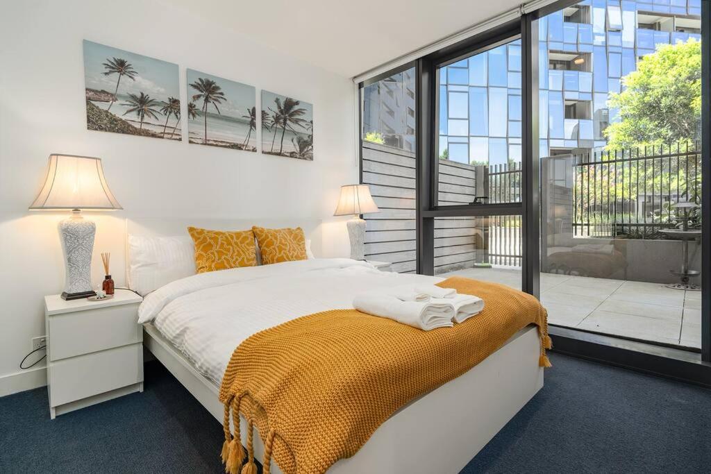 墨尔本2 BD Luxury apartment at heart of Docklands with 85" flat TV & Free Carpark的一间卧室设有一张床和一个大窗户