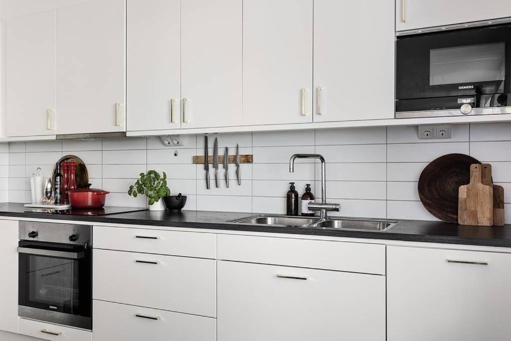 马尔默Tranquil and Convenience Southern Malmo Apartment的白色的厨房配有水槽和微波炉