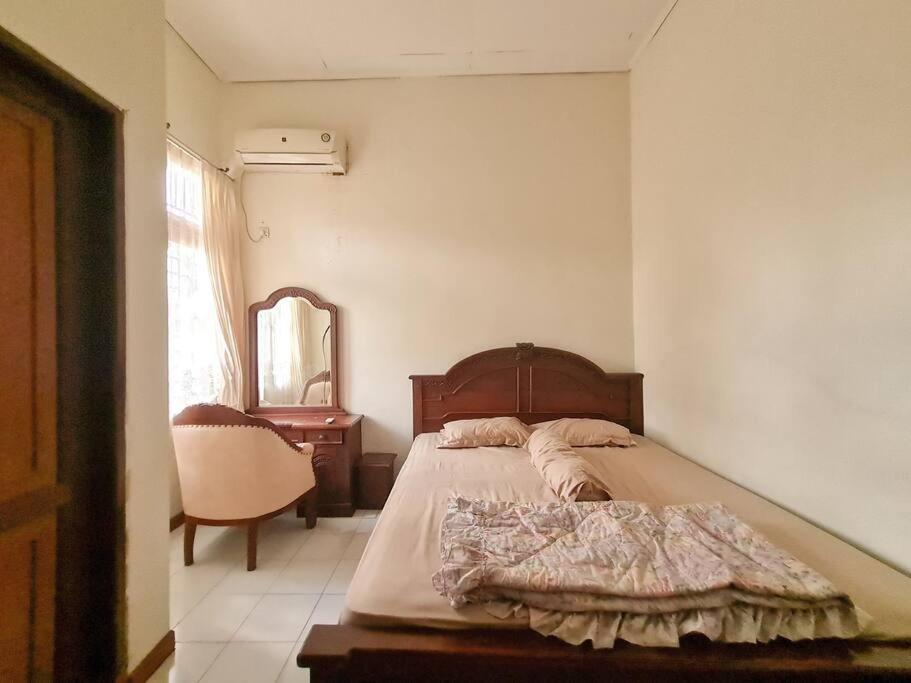 BontangHomestay Pesona Sintuk Bontang A9的一间卧室配有一张床、一把椅子和镜子