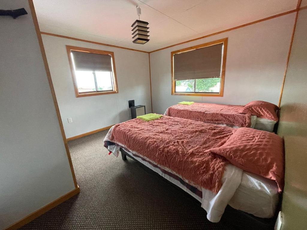 纳塔列斯港Posada De Los Gatos的一间卧室设有两张床和两个窗户。