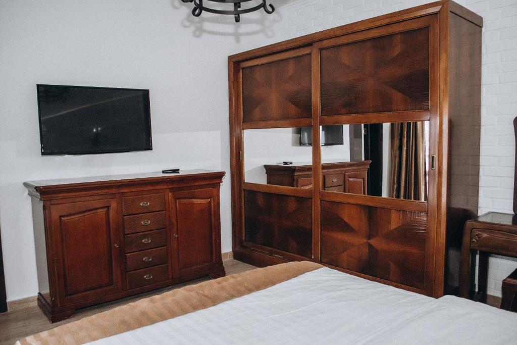 PogrebyDachaLove的一间卧室设有大型木制橱柜和电视