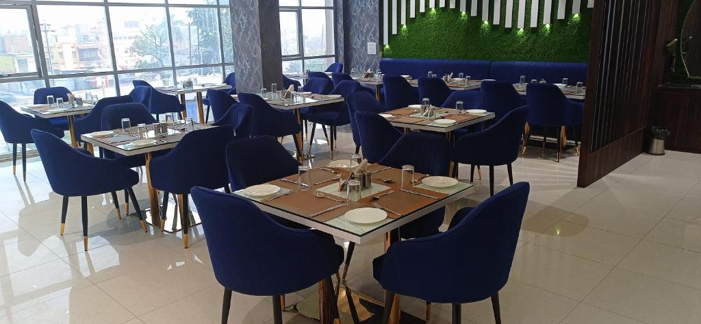 MotīhāriHotel JVW Arena的一间配备有桌子和蓝色椅子的用餐室