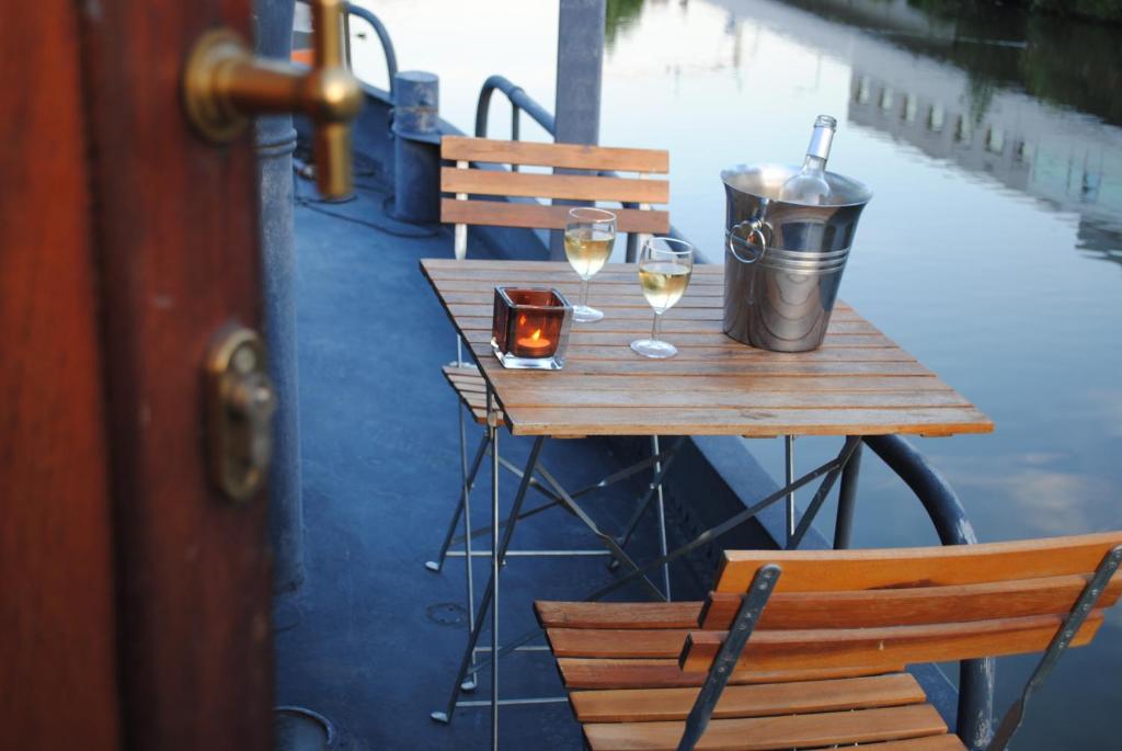 根特Boat & Breakfast Bellevue的一张木桌,上面放着两杯葡萄酒