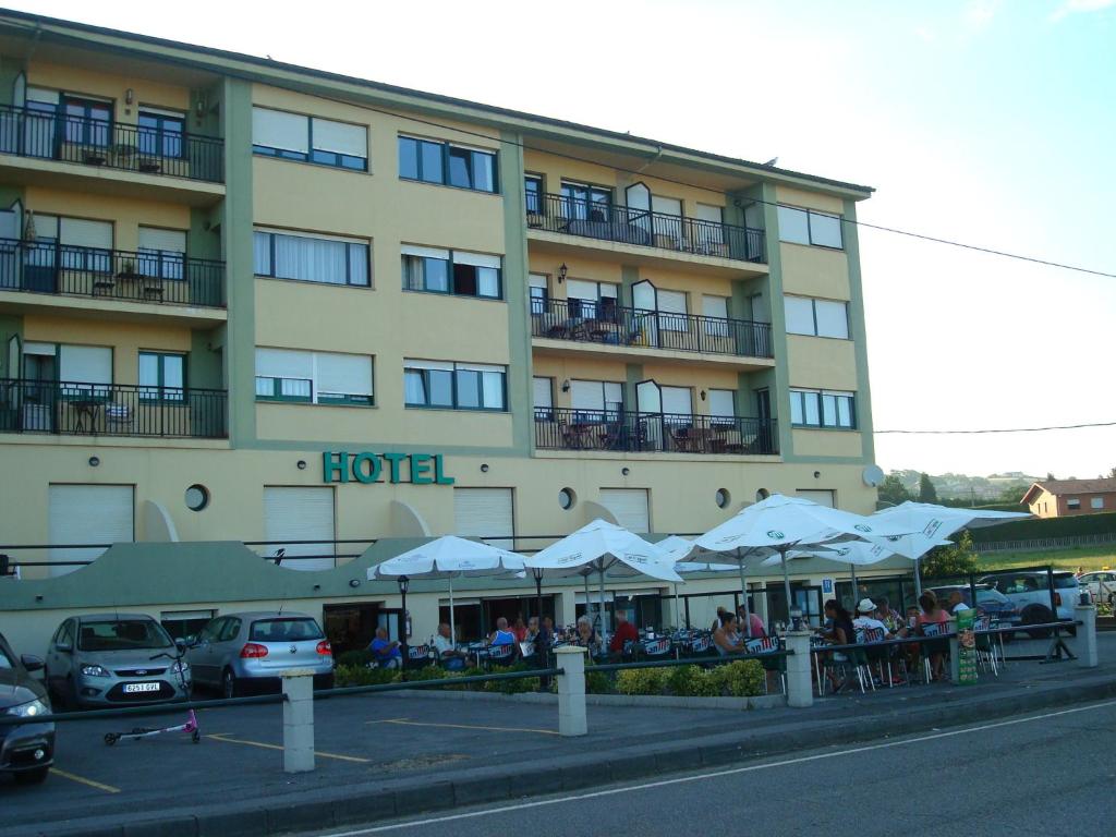 班奴古斯布里萨玛酒店的前面设有桌子和遮阳伞的酒店