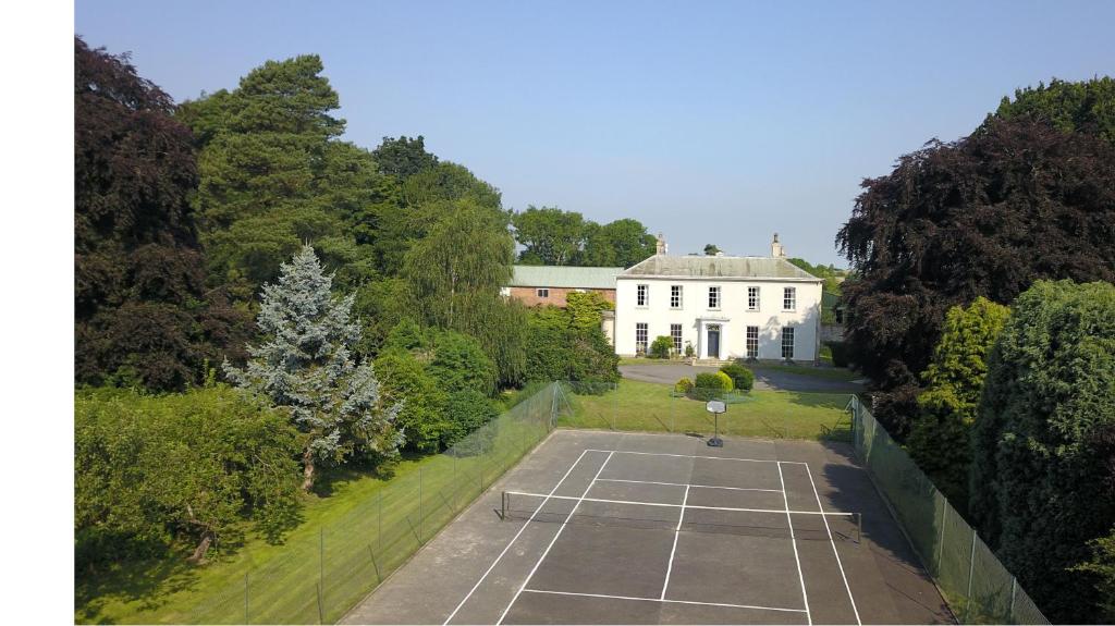 马基特雷森Moortown House的享有带网球场的房屋的空中景致
