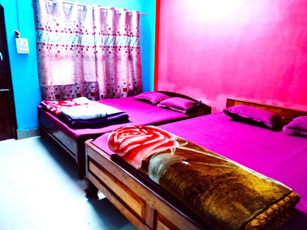 拉塔古里Hotel Green Gold Resort Lataguri的粉红色客房内的两张单人床