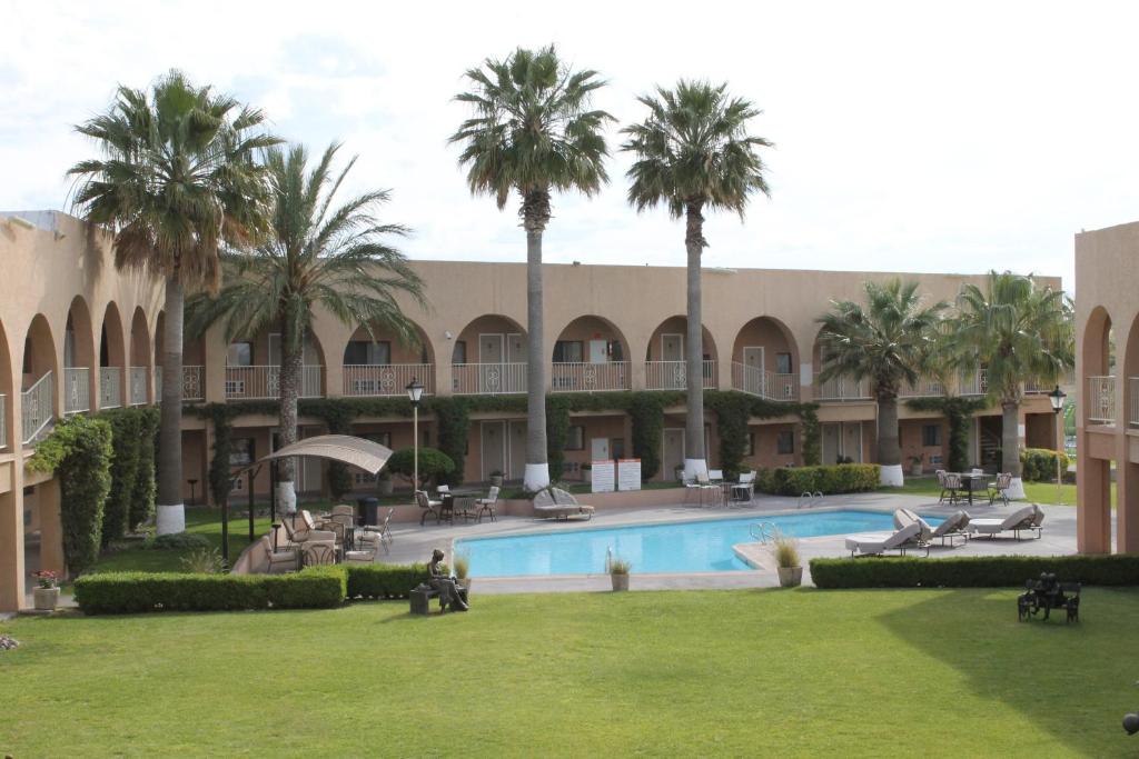Camargo圣达菲酒店的一个带游泳池和棕榈树的度假村