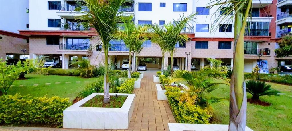 内罗毕the perfect affordable apartments的一座楼前种有棕榈树的庭院