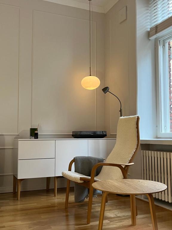 赫尔辛基Central, peaceful, high-end apartment的椅子和桌子以及室内的灯
