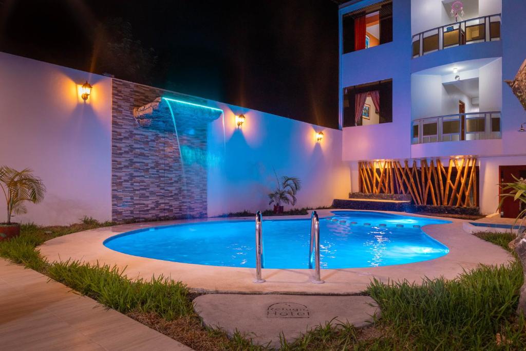 圣拉蒙Refugio Hotel的一座游泳池,在晚上在建筑物前
