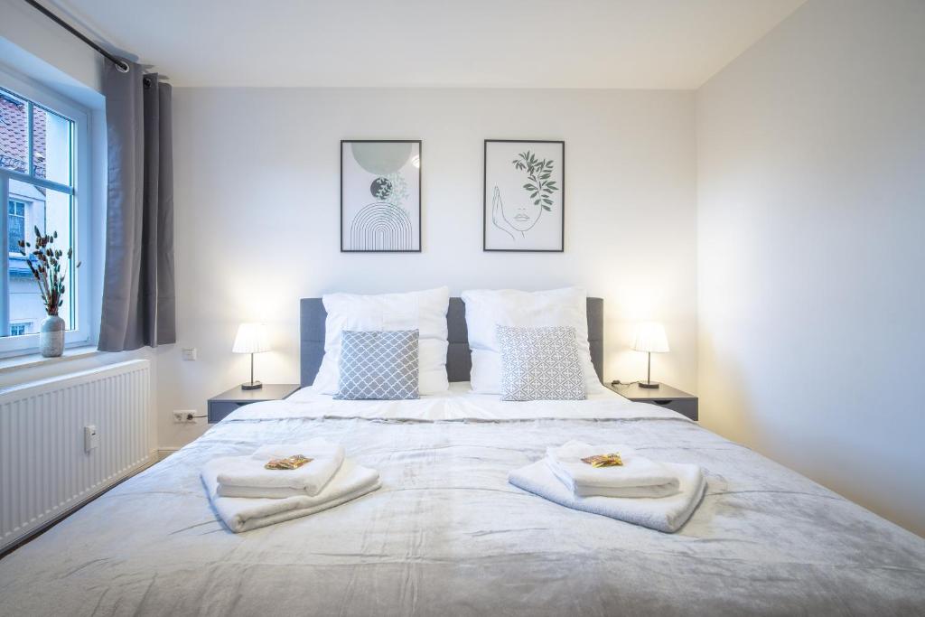 德累斯顿CoView - ruhige Design Wohnung - 2 Schlafzimmer - voll ausgestattete Küche的卧室配有带毛巾的大型白色床