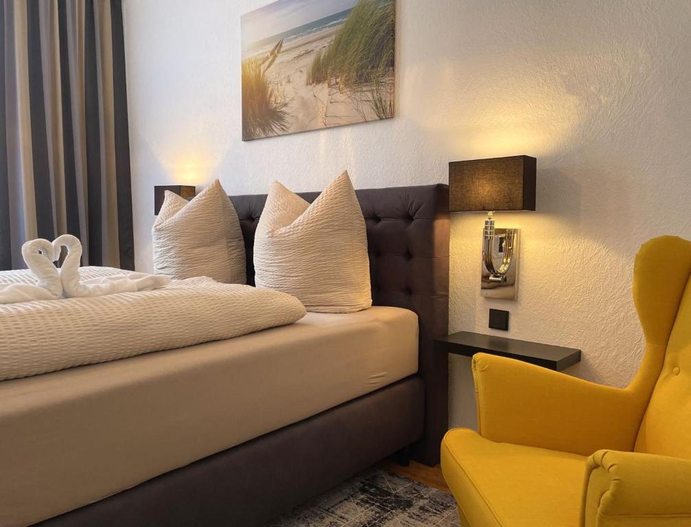 波鸿Hotel Antoni的酒店客房,配有床和黄色椅子