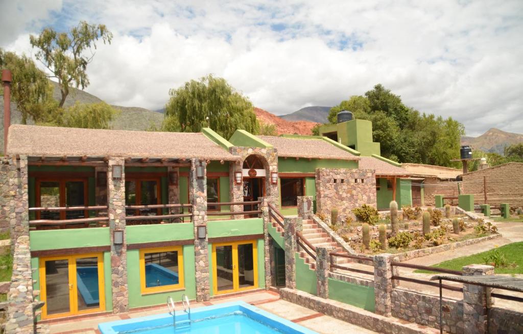 普尔马马尔卡El Refugio de Coquena的一座房子前面设有游泳池