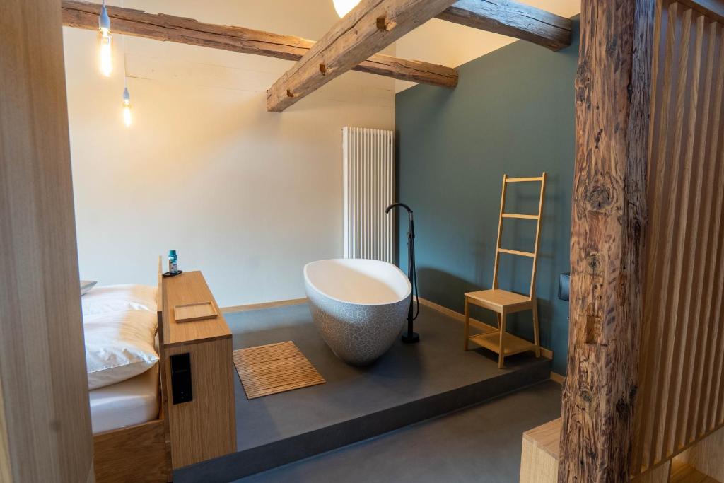 韦尼格罗德Gästehaus Liebfrauen的浴室设有大浴缸,位于床边