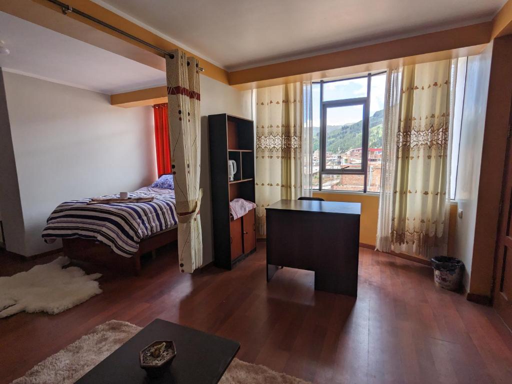 SicuaniMINIDEPARTAMENTO SICUANI的一间卧室配有一张床、一张书桌和一个窗户。