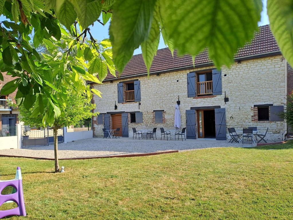 Montigny-les-Monts克洛斯波利住宿加早餐旅馆的院子内带桌椅的砖砌建筑