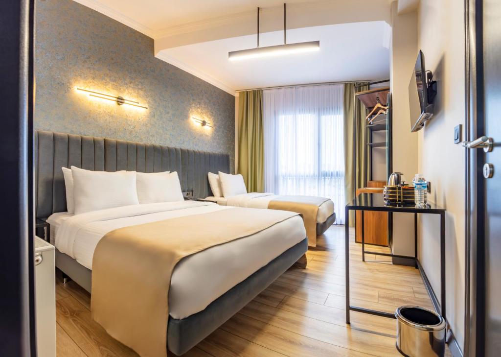 ArnavutköyLenora Airport Hotel的酒店客房设有两张床和电视。