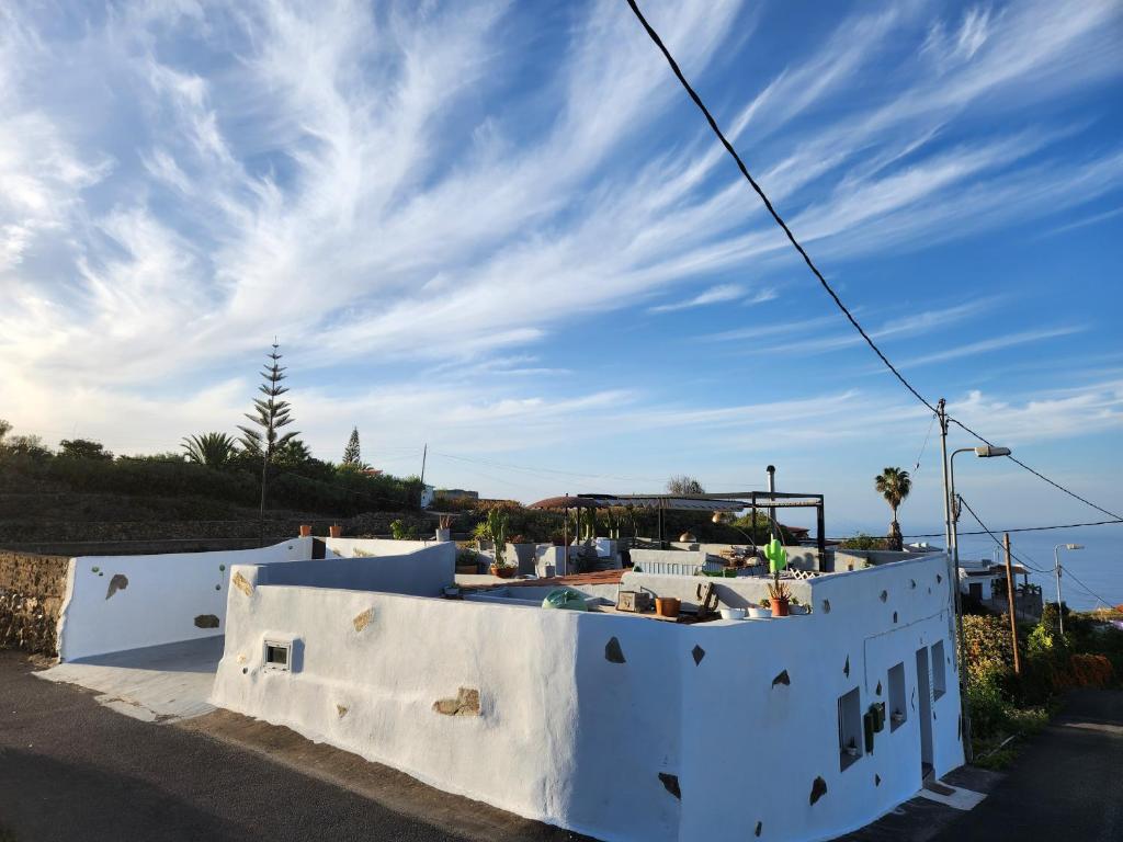 伊科德洛斯维诺斯Casa Salvia Bed and Breakfast的白色墙壁和蓝色天空的房子