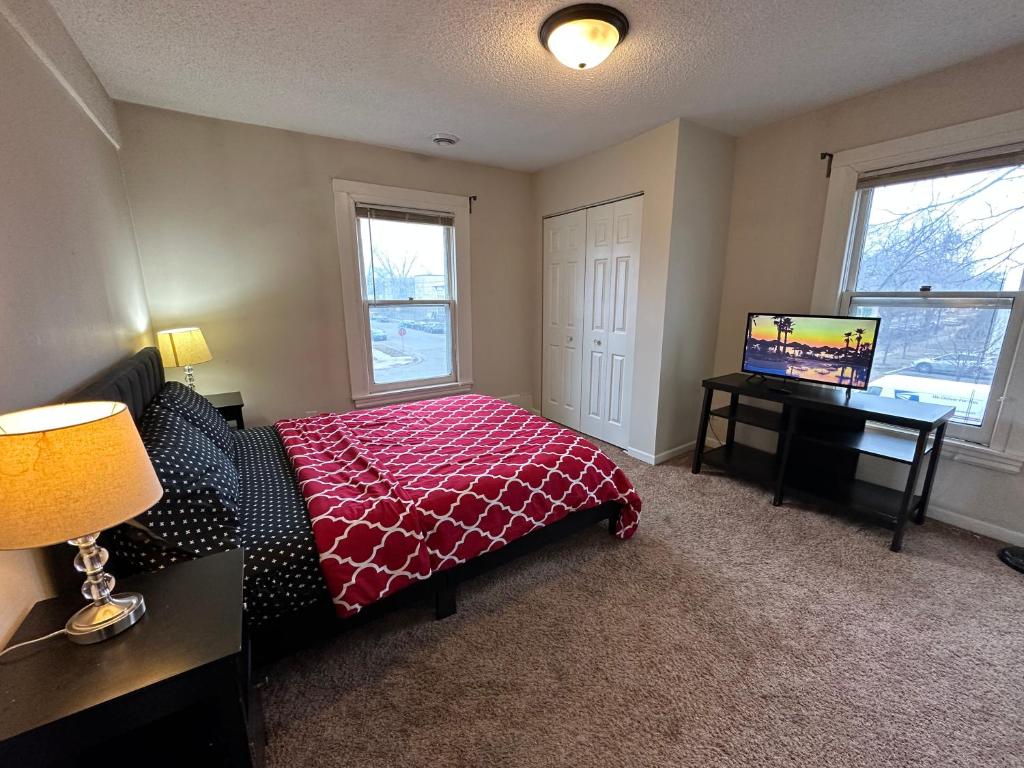 明尼阿波利斯Lyndale Oasis的一间卧室配有一张床、一张书桌和一台电视