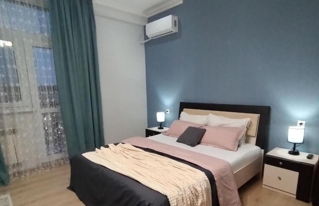 阿克套Однокомнатные апартаменты в золотом квадрате ЖК GREEN PLAZA的一间卧室配有带粉红色枕头的床和窗户。
