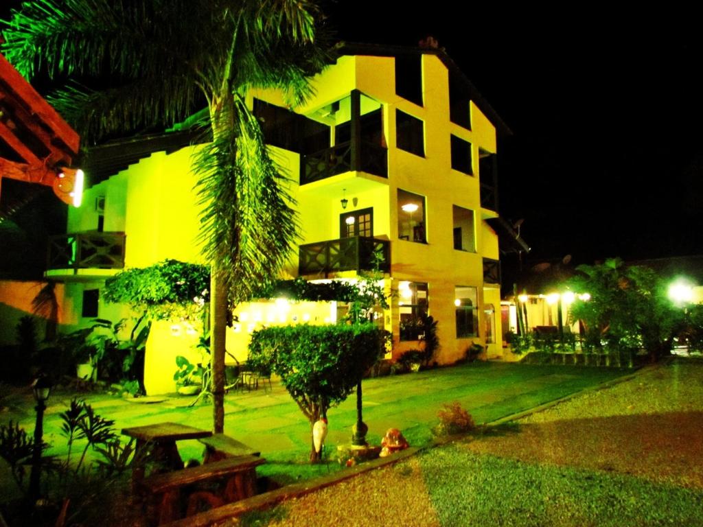 沙帕达-杜斯吉马朗伊斯望厦别墅吉马良斯旅馆的一座黄色的建筑,前面有棕榈树
