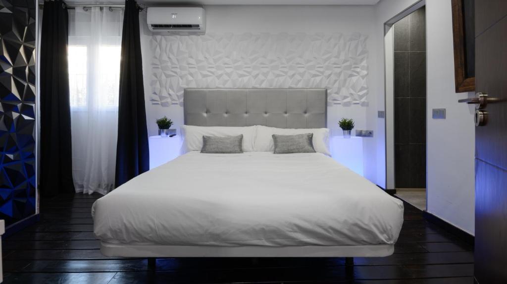 马拉加Malaga Chic jacuzzi y playa的卧室配有一张带两个枕头的大白色床