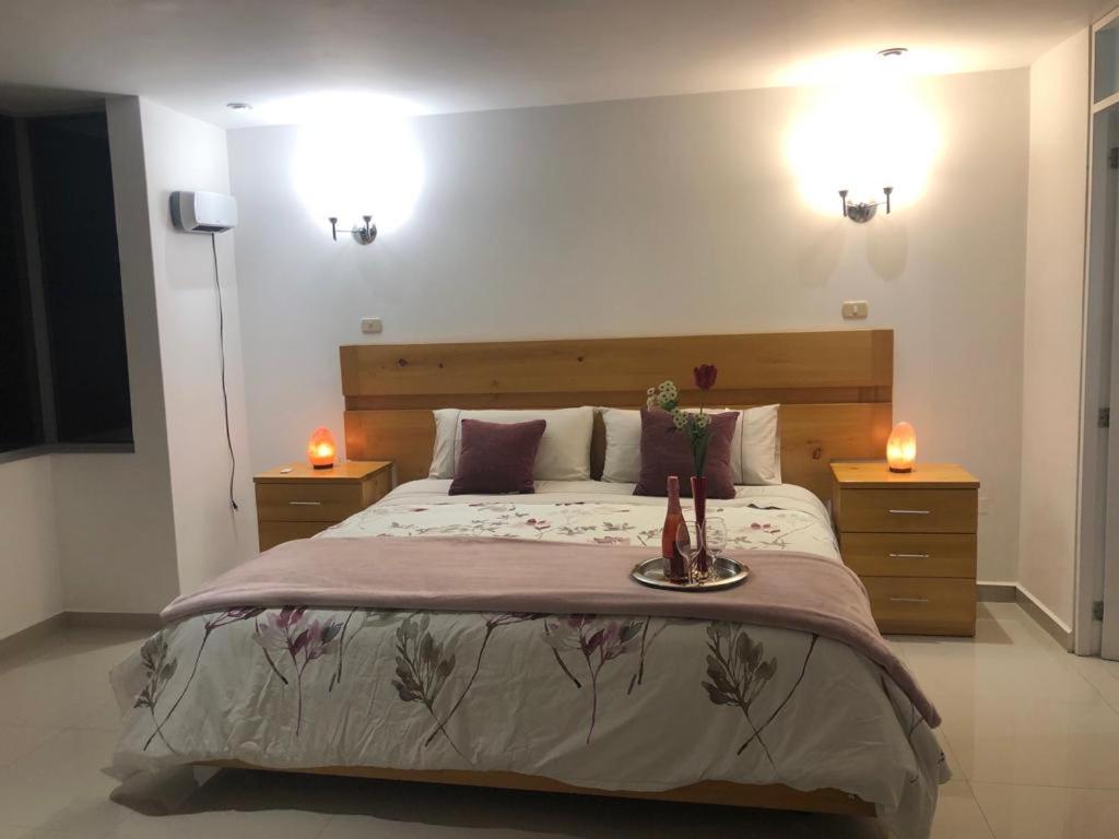 卡哈马卡HOTEL CB CAJAMARCA HUACARIZ的一间卧室配有一张带两张蜡烛的大床