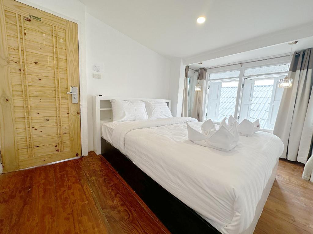 清迈SherVa101 Home and Hostel的卧室配有白色大床和白色枕头