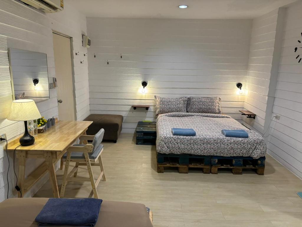 曼谷拉罗坎达酒店的一间卧室配有一张床和一张木桌