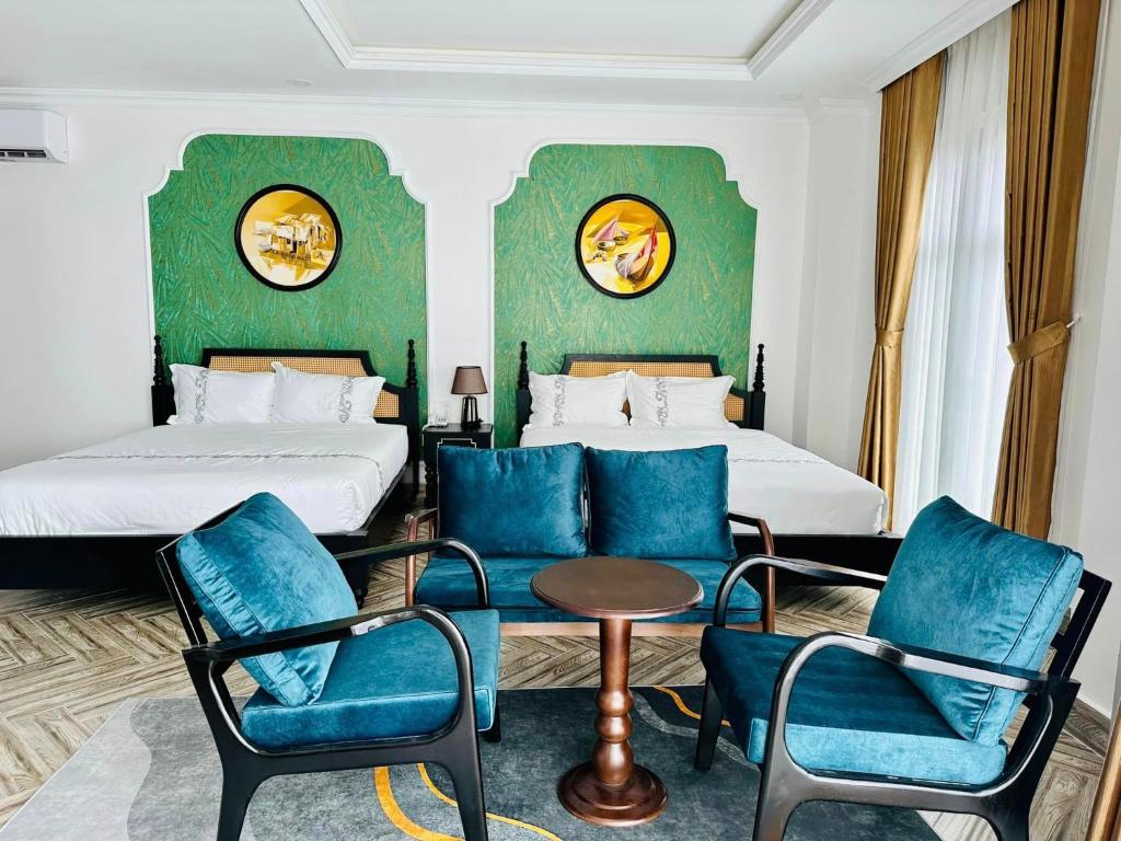 金瓯Khách Sạn The One Hotel 1的酒店客房,配有两张床和蓝色椅子