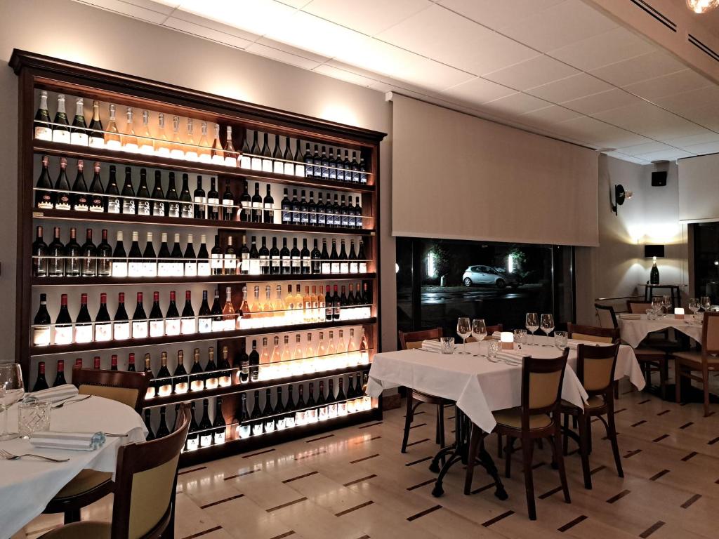 布雷谢洛BRIXELLUM的餐厅设有桌子和一堵大墙的葡萄酒瓶