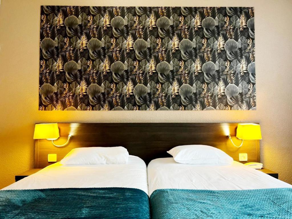 日安Brit Hotel Confort Gien的墙上画画的房间里设有两张床