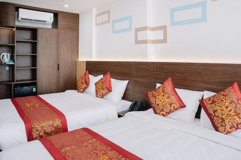 归仁Gia Kiên Hotel的酒店客房设有两张床和电视。